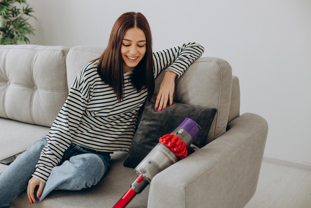 woman doing house work with rechargeable vacuum cleaner