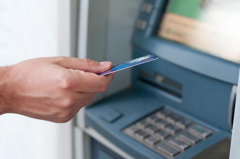 hand inserting atm card into bank machine withdraw money businessman men hand puts credit card into atm